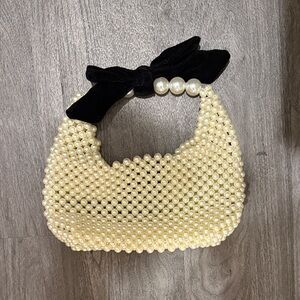 Elegant Pearl-Embellished Cream Bag with Black Bow